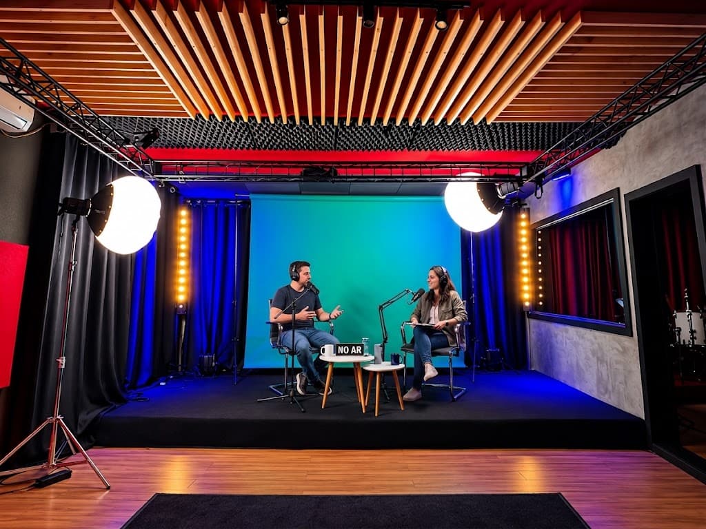 Dois apresentadores com fones e microfones de braço diante do fundo de chroma key, com placa NO AR e softboxes